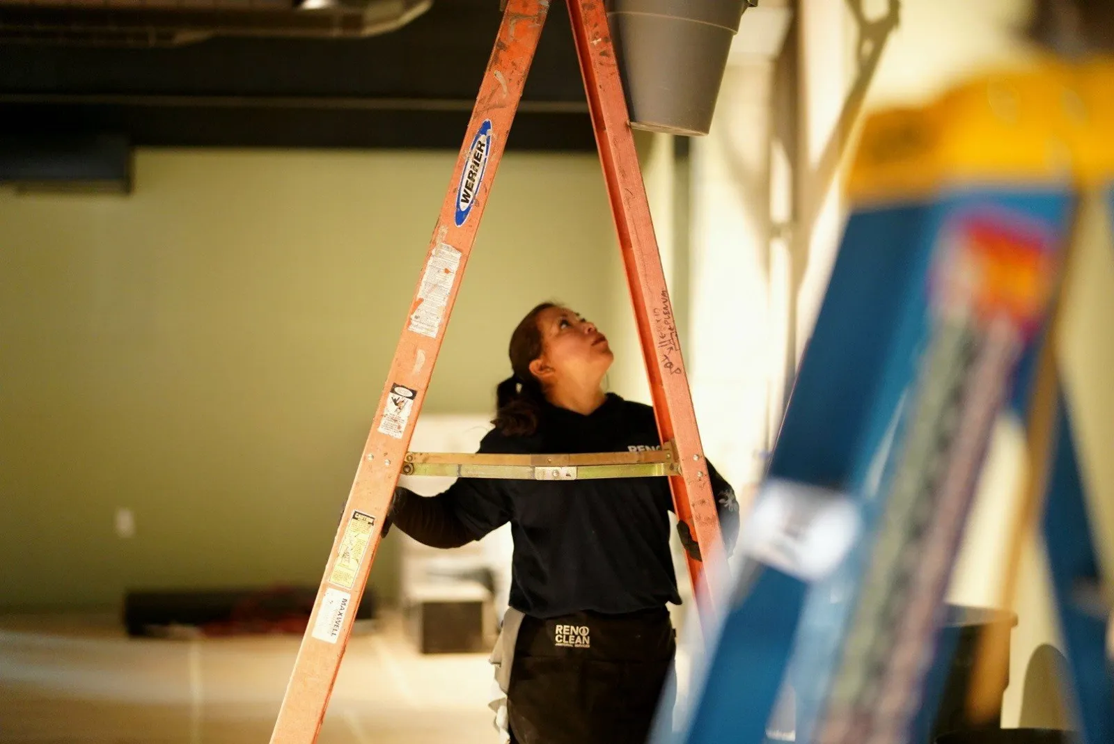 Reno Clean crew member cleaning from a ladder